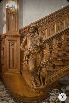 a statue of a man with a dog on the stairs next to a stair case