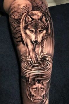 a man's leg with a wolf and water reflection tattoo on the calfs