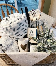 a basket filled with lots of stuff animals and coffee mugs on top of a table