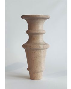 a tall wooden vase sitting on top of a white table