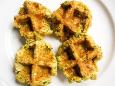 four pieces of fried food on a white plate with a fork next to the dish