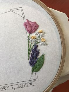 a close up of a embroidery on a piece of cloth with flowers in the middle