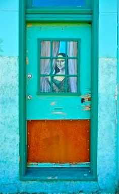 a blue door with a woman looking out the window