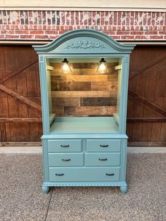 an old dresser is painted blue and has been turned into a shelf with lights on top