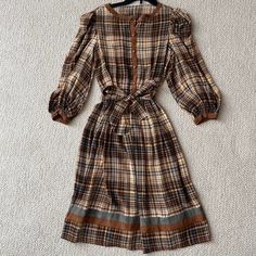 Stunning Vintage Brown Checkered Silk Dress! Buttons Up The Front And At The Cuffs And Can Be Tied At The Waist. Still Looks Brand New. No Tags, But Most Likely A Size 4 Or 6, And Seen On A Model With A 36” Bust, 26” Waist, And 35” Hips For Reference. Please Feel Free To Pm Me With Any Questions! Fitted Brown Plaid Dress For Spring, Knee-length Plaid Dress For Brunch, Brown Gingham, Brown Checkered, Dress Buttons, Gingham Dress, Vintage Brown, Silk Dress, Gingham