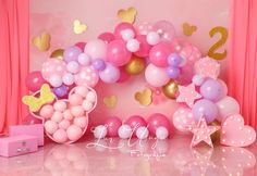 a pink and gold birthday party with balloons, streamers, stars, and decorations