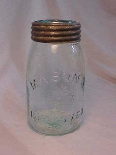 a glass jar with a metal lid on a white background