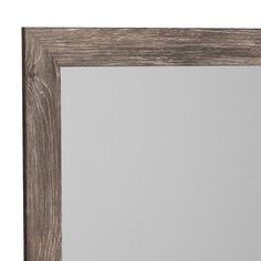 a wooden frame mirror on a white wall