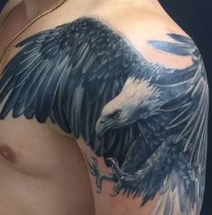 an eagle tattoo on the arm and chest is shown in black and grey colors with white accents