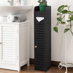 a tall black cabinet next to a white sink