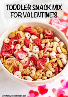 a bowl filled with cereal and fruit on top of a pink table cloth next to a red heart shaped napkin