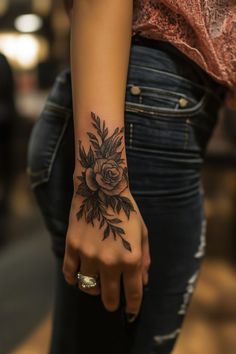 a woman's hand with a flower tattoo on it