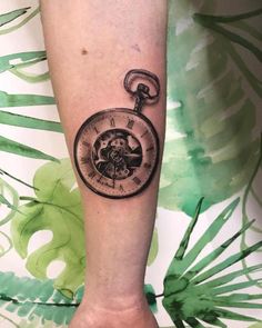 a person with a tattoo on their arm has a pocket watch in the shape of a heart