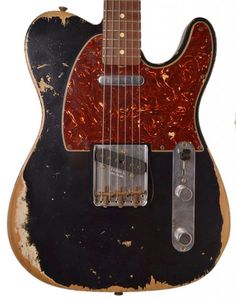 an old black and red guitar is on display