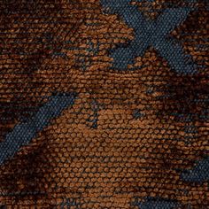 a close up view of an orange and blue carpet with dark brown spots on it