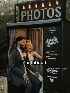 a man and woman are sitting in a photo booth with lights on the top of them