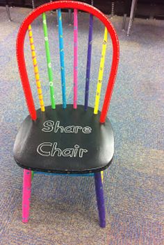 there is a chair that has been painted with different colors and writing on the back