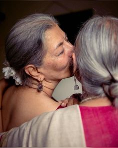 two older women are kissing each other