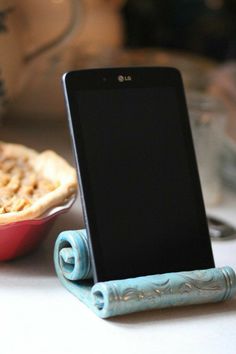 a cell phone sitting on top of a table next to a pie