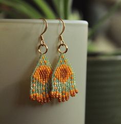 Orange and blue/green beaded earrings - Two tones of orange beads with semi-clear blue/green background - Beaded earrings handmade with care Handmade Orange Teardrop Beaded Earrings, Orange Teardrop Beaded Earrings With Ear Wire, Orange Teardrop Beaded Earrings With Dangling Beads, Orange Faceted Beads Earrings For Gifts, Orange Faceted Beaded Earrings For Gift, Orange Beaded Earrings With Tiny Round Beads, Orange Beaded Earrings With Round Beads, Orange Round Beaded Earrings With Ear Wire, Orange Teardrop Beaded Earrings