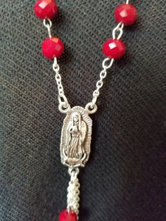 "This handmade Virgen De Guadalupe Necklace is made using Silver Tone curb chain that has triple layer and strung on 2 jump rings. Next are hand beaded individual links that connect to 12 connectors. At the bottom is a Silver Tone Medal of La Virgen De Guadalupe and on the reverse side has the wording \"Our Lady of Guadalupe\". Below that is a small jump ring with 4 2 1/2\" Chains with 2 chain and bead connector. All material used is new and non-vintage items. This necklace will arrive in a gift Red Beaded Dangle Necklaces, Necklaces Guadalupe, Adjustable Red Beaded Rosary, Multicolor Our Lady Of Guadalupe Jewelry As A Gift, Oval Our Lady Of Guadalupe Necklace For Gift, Guadalupe Necklace, Spiritual Silver Necklace With Our Lady Of Guadalupe, Rosary Style Necklace, Spiritual Our Lady Of Guadalupe Pendant Necklace