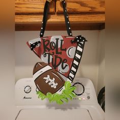 a handbag hanging from the side of a dryer with football decorations on it