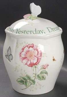 a white ceramic jar with a pink flower and butterfly on the lid that says, our yesterday, dear