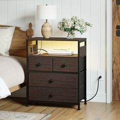 a night stand with drawers and a lamp on top