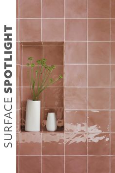 a plant in a white vase sitting on a shelf next to a pink tiled wall