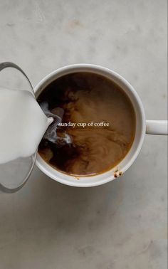 milk being poured into a cup of coffee