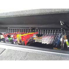 an open trunk filled with assorted items and hanging from it's side rail