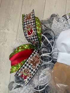 a christmas mesh wreath with gingerbreads and snowmen on it, sitting on the floor