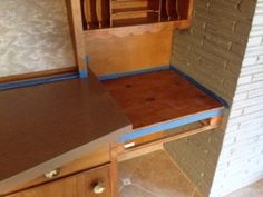 an unfinished kitchen counter is shown with blue tape on the top and bottom part of it