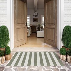 an open door leading into a living room with potted plants on either side of the doorway