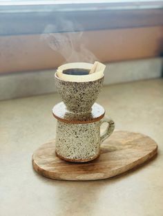 a coffee cup sitting on top of a wooden coaster