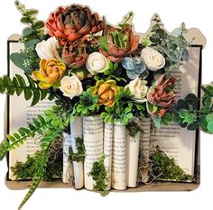 an arrangement of flowers in vases sitting on top of books