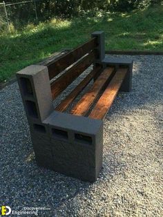 a wooden bench sitting on top of a gravel field