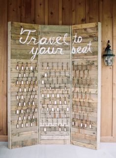 a room divider made out of wooden boards with words written on it and some lights attached to the sides