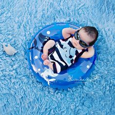 a baby laying on top of a blue inflatable ring