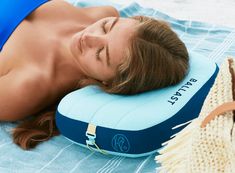 a woman laying on top of a blue pillow