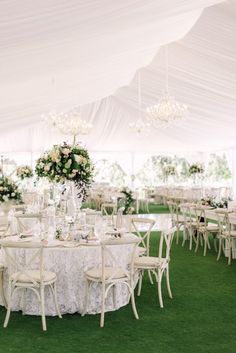 an outdoor tent with tables and chairs set up for a formal dinner or wedding reception