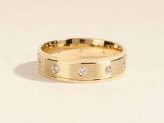 a yellow gold wedding band with three diamonds