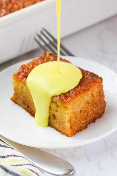 a piece of cake is being drizzled with yellow sauce