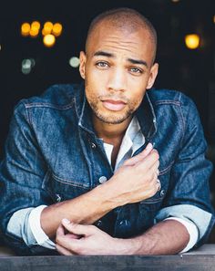 a man sitting at a table with his arms crossed in front of him and looking off to the side