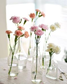 several vases with flowers in them sitting on a table