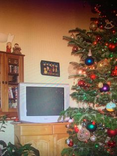 a christmas tree is in front of a television