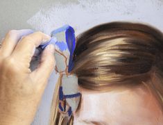 a woman is painting the wall with blue and white paint on her head while she brushes her hair