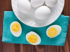 an image of hard boiled eggs on a plate with blue cloth and napkins next to it