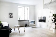 a living room filled with furniture and a flat screen tv sitting on top of a wooden floor