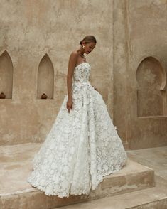 a woman in a white wedding dress standing on steps